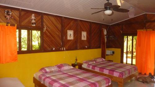 a bedroom with two beds and a ceiling fan at Fidelito Ranch & Lodge in Tambor