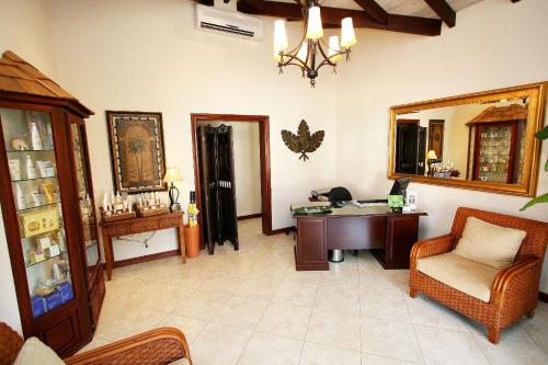 a living room with a desk and a mirror at Sugar Cane Club Hotel & Spa in Saint Peter