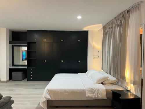 una camera da letto con un grande letto con testiera nera di Hotel Nanon Sathorn a Bangkok