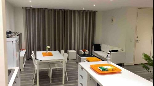 a living room with two tables and a couch at Mak's Short Stay in Werribee
