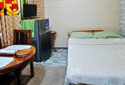 a room with a bed and a table and a table sidx sidx at RedDoorz Hostel @ Faes Transient House in Baguio
