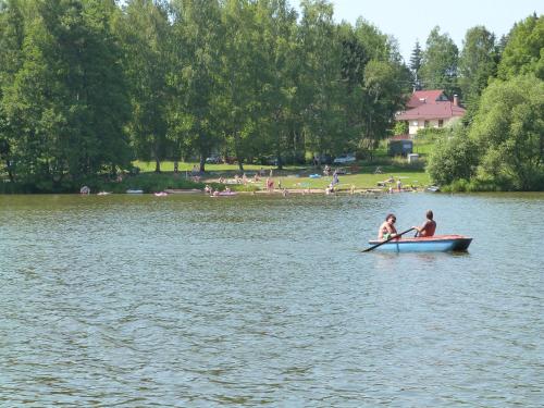 two people in a row boat on a lake at Rekreační chaty Malý Ratmírov in Malý Ratmírov