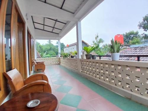 a balcony with a table and chairs and plants at D'Bondowoso Homestay Magelang RedPartner in Sumberrejo