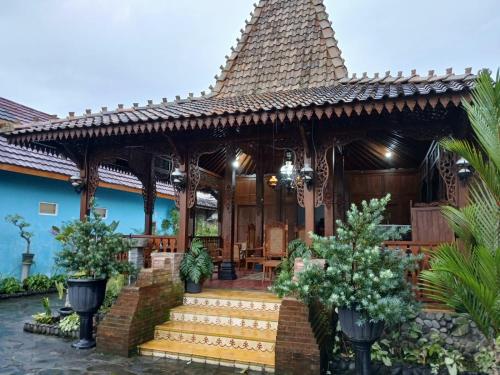 a house with a pavilion with stairs and trees at D'Bondowoso Homestay Magelang RedPartner in Sumberrejo