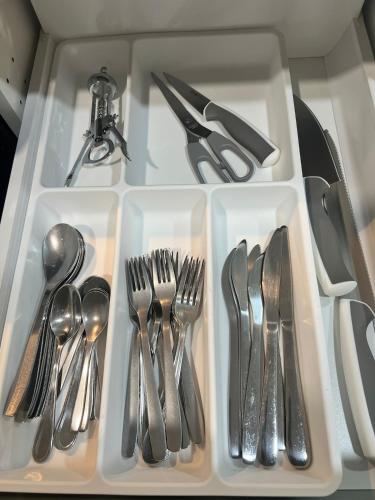 a white tray with silver utensils on a table at 10 minutes to Montreal entire place 2 bedrooms private entrance in Laprairie