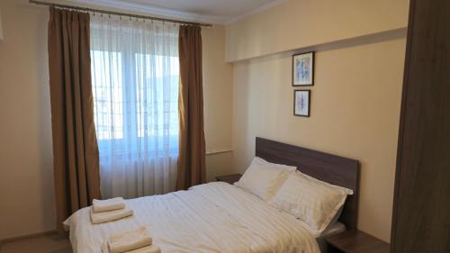 ein Schlafzimmer mit einem Bett und einem Fenster mit Handtüchern darauf in der Unterkunft Tineretului in Bukarest