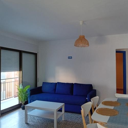 a living room with a blue couch and a table at María PLAYA ARENA NG in Peniscola