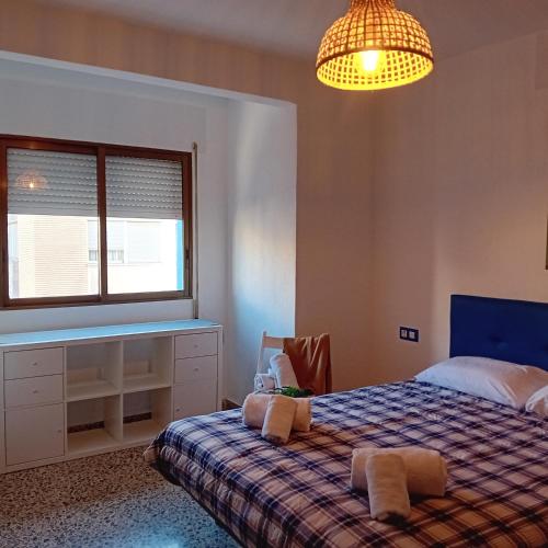 a bedroom with a bed and a window and a chandelier at María PLAYA ARENA NG in Peniscola