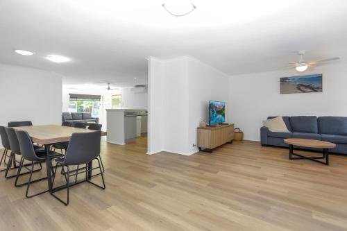 a living room with a table and chairs and a couch at Saltwater Retreat Hawks Nest in Hawks Nest