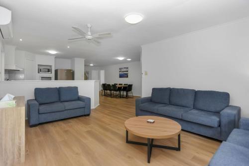 a living room with two blue couches and a table at Saltwater Retreat Hawks Nest in Hawks Nest