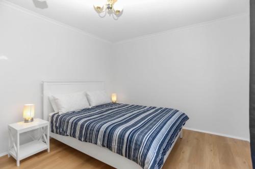 a white bedroom with a bed and a night stand at Saltwater Retreat Hawks Nest in Hawks Nest