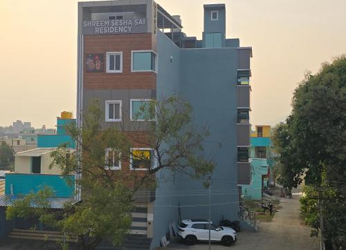 a building with a car parked in front of it at Shreem Sesha Sai Residency in Tiruvannāmalai