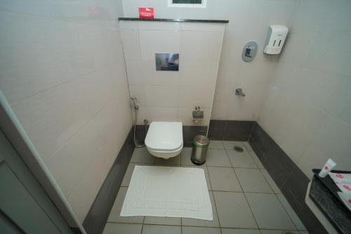 a small bathroom with a toilet in a stall at Zip by Spree Hotels Mangala International in Coimbatore
