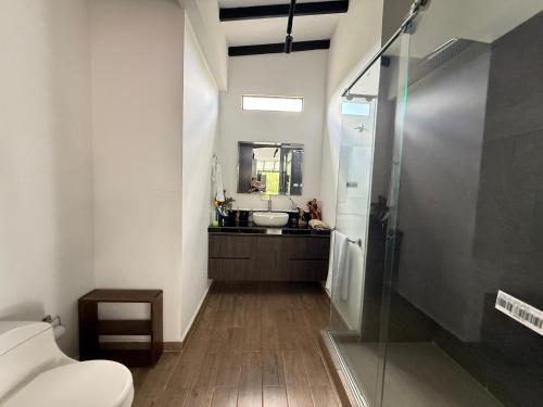 a bathroom with a sink and a toilet and a mirror at Villa del lago in Quimbaya