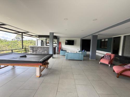 a living room with a ping pong table in the middle at Villa del lago in Quimbaya