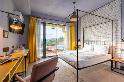 a bedroom with a bed and a desk and a window at Hotel Casa Art in Oreshak