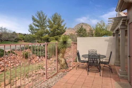 a patio with a table and chairs and a fence at Refreshing Sedona Sanctuary with Pool and Hot Tub for Family in Sedona
