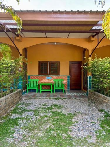 a patio with a table and benches on a house at SUAN SANG CHAN RIVERSIDE Resort สวนแสงจันทร์ ริเวอร์ไซด์ รีสอร์ท in Ban Bang Khoi