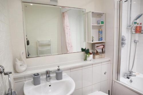 a white bathroom with a sink and a mirror at Luxury Apartment New Street Birmingham in Birmingham
