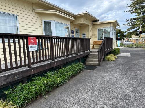a house with a wooden fence in front of it at Airport Westney Lodge in Auckland