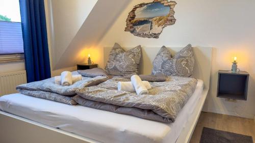 a bedroom with a bed with pillows and a tv at Haus-Nordseeperle-11 in Cuxhaven