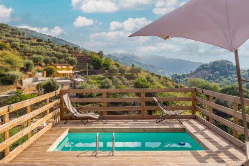 a pool on a wooden deck with an umbrella at Rustico immerso nella natura a due passi dal mare in Strettoia