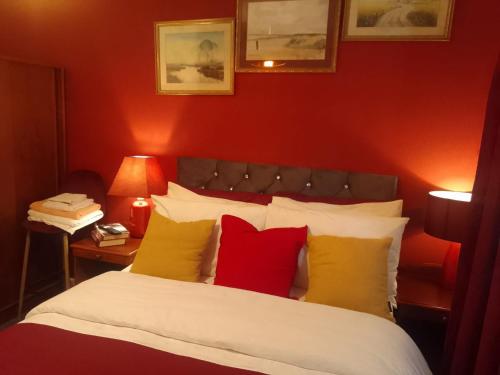 a bedroom with a bed with red and yellow pillows at 10 Guests - Garden - Quiet Retreat Cottage in Walsall