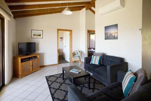 a living room with two couches and a tv at Chandlers Smiths Beach Villas in Yallingup