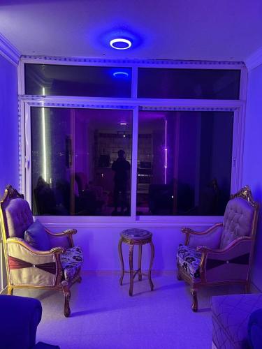 a purple room with chairs and a table and a window at شاليهات الهنا 2 للإيجار مصيف قرية النورس الاسماعيلية in Ismailia