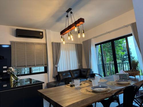 a kitchen and dining room with a table and chairs at Tanouy Garden in Baan Khai