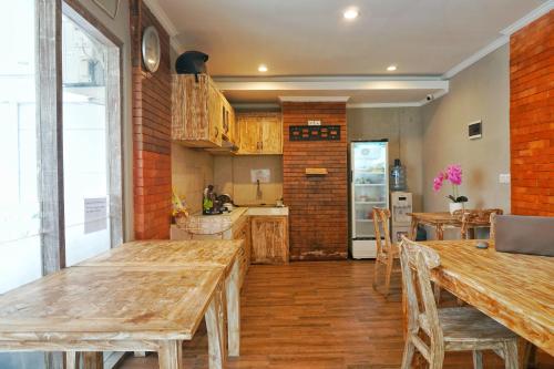 a kitchen with wooden tables and a brick wall at Koura Jimbaran in Badung