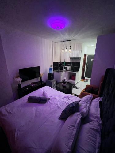 a purple bedroom with a bed and a purple light at Luxore Apartments Syokimau No E311 in Nairobi