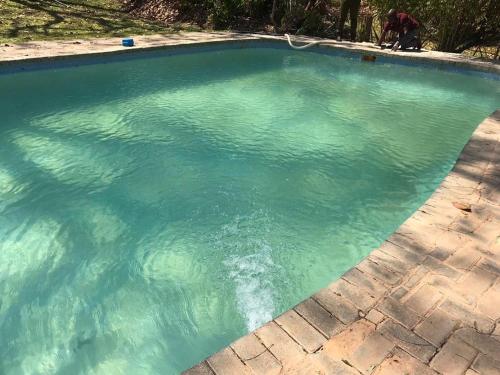 a pool of blue water with a person in it at Nsobe Game Camp in Masaiti