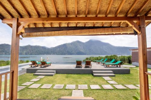 a pavilion with chairs and a view of the water at D Sila's Tepi Danu Villas Kintamani & Natural hot spring in Kintamani