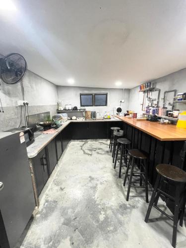 a large kitchen with a counter and stools in it at Kerlingfornia Pond View Homestay in Kerling