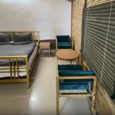 a room with two beds and a table and chairs at The Chail Heights Hotel and Resort in Chail