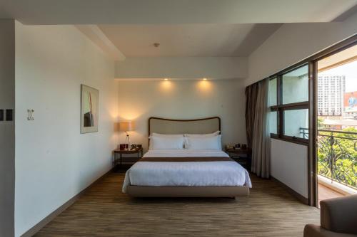 a bedroom with a bed and a large window at La Breza Hotel in Manila
