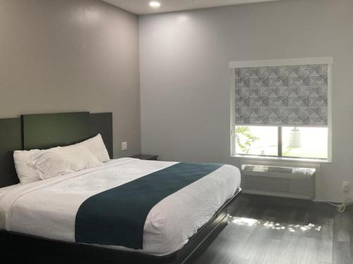 a bedroom with a large bed and a window at Studio 6 Suites Brenham, TX in Brenham