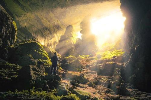 a man standing in front of a cave at Pu Luong Paradise in Hương Bá Thước