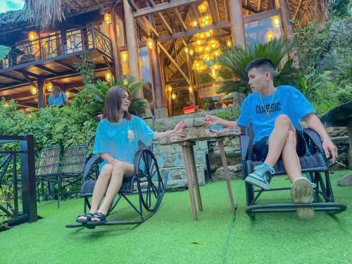 a man and a woman sitting at a table at Pu Luong Paradise in Hương Bá Thước