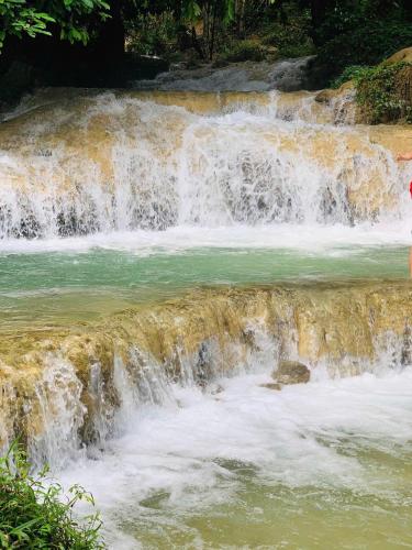 a waterfall in the middle of a river at Pu Luong Paradise in Hương Bá Thước