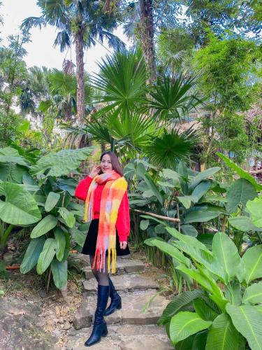 a woman wearing a colorful scarf standing on some stairs at Pu Luong Paradise in Hương Bá Thước