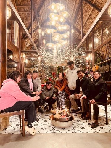 a group of people sitting around a fire in a room at Pu Luong Paradise in Hương Bá Thước