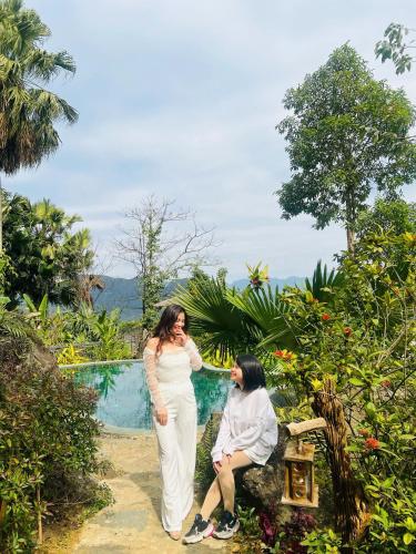 two women are standing next to a pool at Pu Luong Paradise in Hương Bá Thước