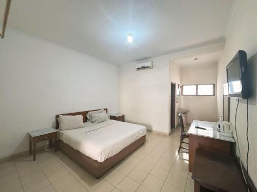 une chambre avec un lit et une télévision dans l'établissement yaemal frances hotel, à Bandung