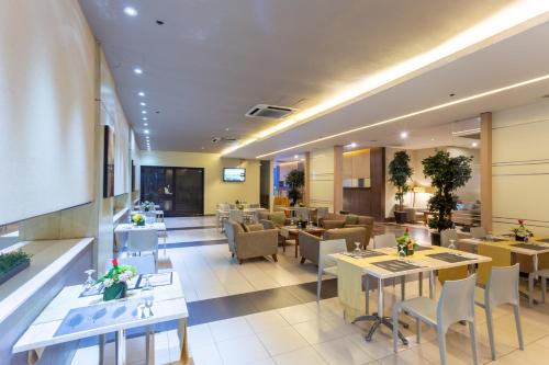 a restaurant with tables and chairs in a building at La Breza Hotel in Manila