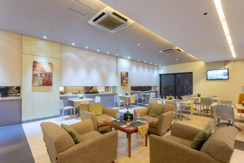 a lobby with chairs and tables and a bar at La Breza Hotel in Manila