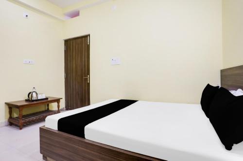 a bedroom with a bed and a table in it at Hotel O Divisha palace in Gaya