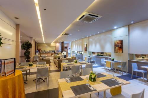 a dining room with tables and chairs and a restaurant at La Breza Hotel in Manila