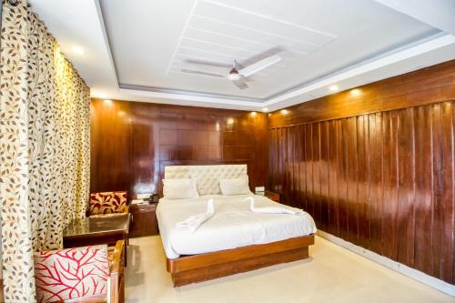 a bedroom with a bed and a wooden wall at Deep Hotel in Mussoorie